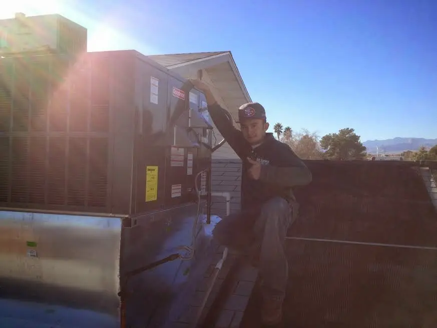 HVAC technician performing AC Tune-Up on a rooftop unit in Allegany